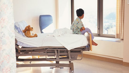 Hospital and Surgery Centers - boy staring out window while sitting on hospital bed
