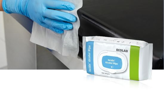 Person in blue gloves cleaning a black surface with an Incidin Alcohol Wipe, with the product package visible in the image.